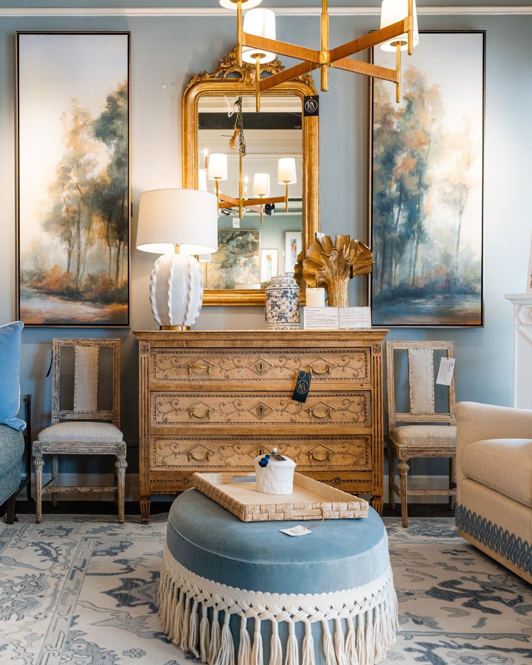 Kathy Adams showroom vignette — gilt antique mirror and carved chest mixed with modern upholstery