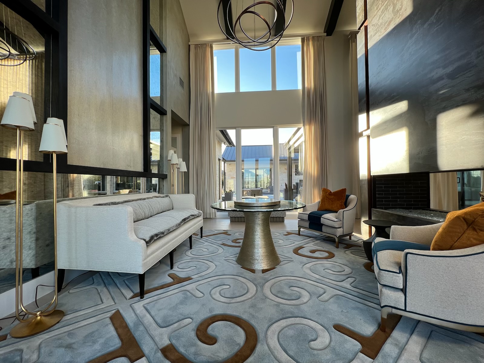 Finished installed living room with custom rug, glass-top table, and floor-to-ceiling windows